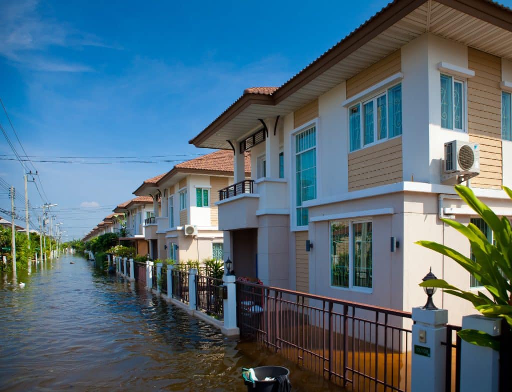A flooded street along a row of houses.